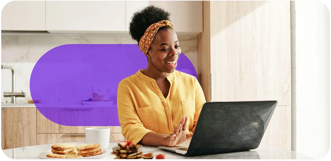 A person smiling while using a laptop to transfer prescriptions
